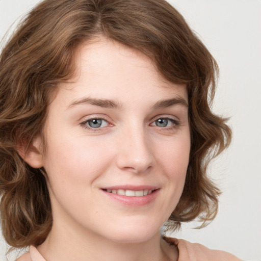 Joyful white young-adult female with medium  brown hair and green eyes