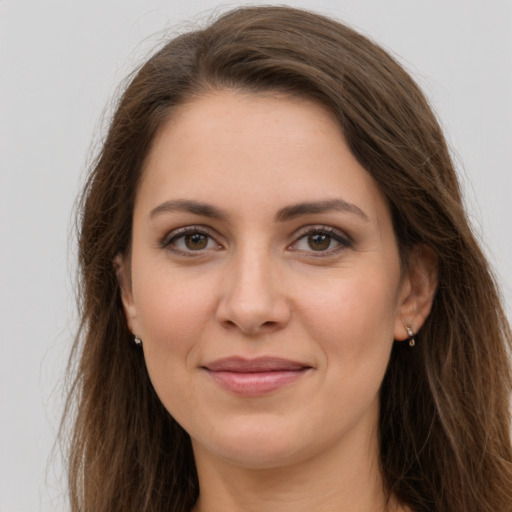 Joyful white young-adult female with long  brown hair and brown eyes