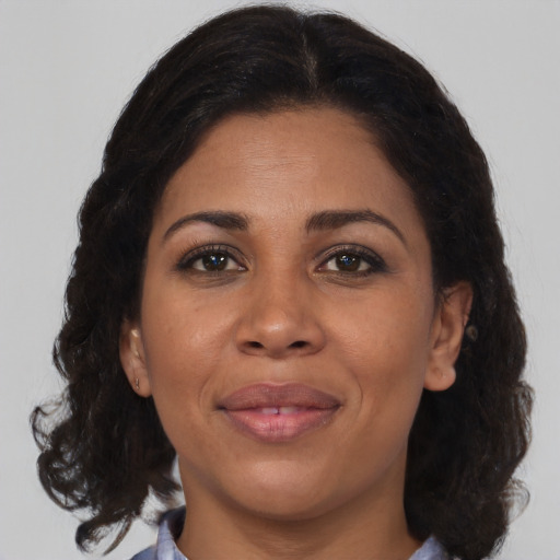 Joyful black adult female with medium  brown hair and brown eyes