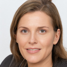 Joyful white adult female with long  brown hair and grey eyes