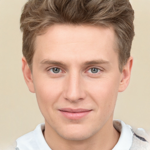 Joyful white young-adult male with short  brown hair and grey eyes