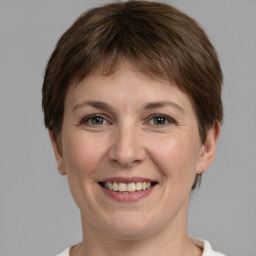 Joyful white adult female with short  brown hair and grey eyes