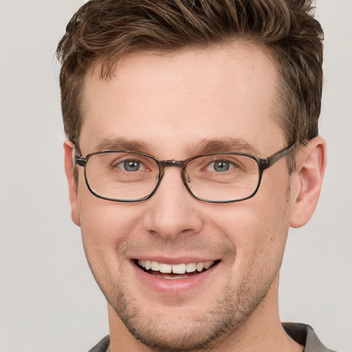 Joyful white young-adult male with short  brown hair and grey eyes