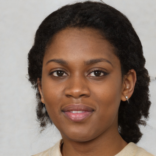 Joyful black young-adult female with medium  black hair and brown eyes