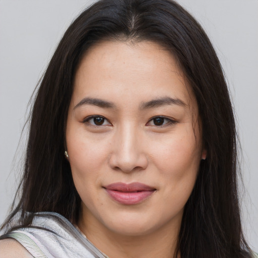 Joyful asian young-adult female with long  brown hair and brown eyes