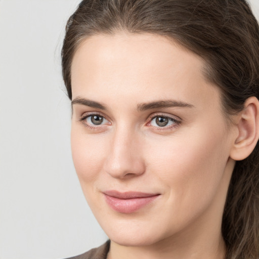 Joyful white young-adult female with long  brown hair and grey eyes