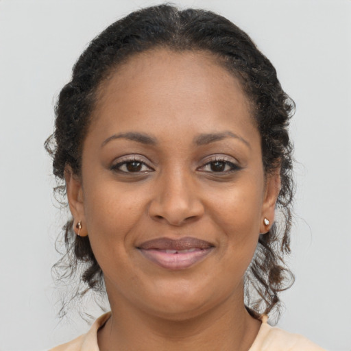 Joyful black adult female with long  brown hair and brown eyes