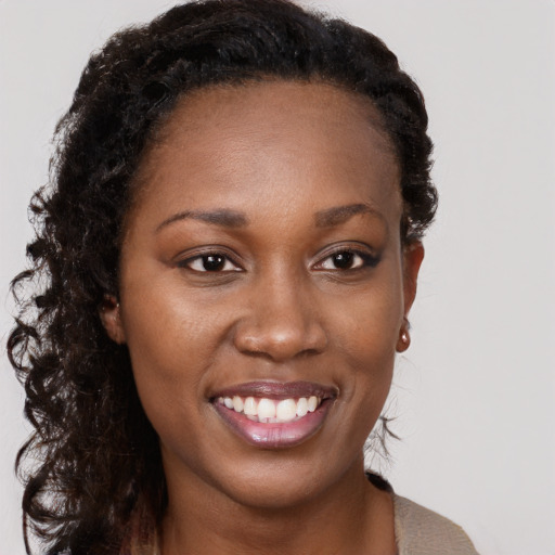 Joyful black young-adult female with long  brown hair and brown eyes