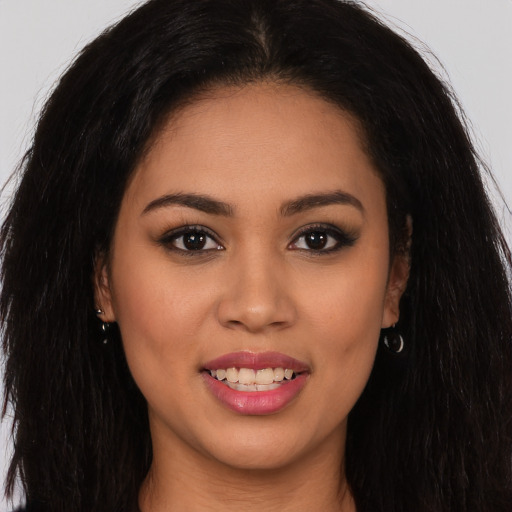 Joyful latino young-adult female with long  brown hair and brown eyes