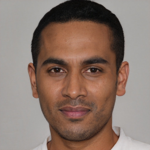 Joyful latino young-adult male with short  black hair and brown eyes