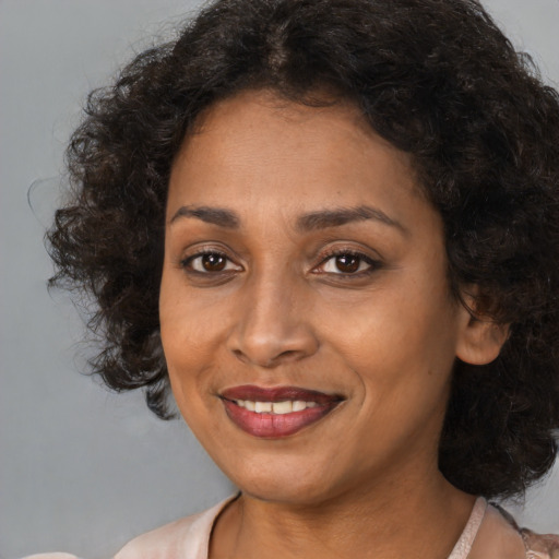 Joyful black young-adult female with medium  brown hair and brown eyes