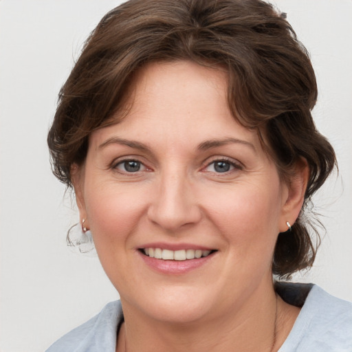 Joyful white adult female with medium  brown hair and grey eyes