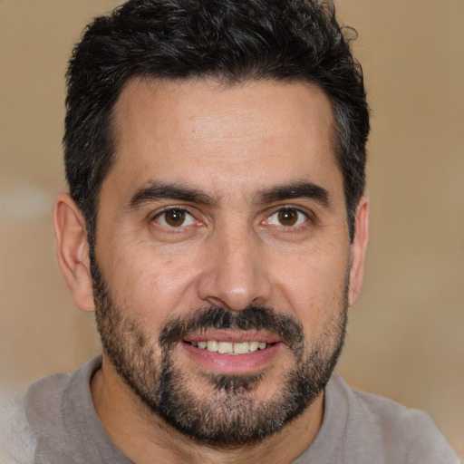 Joyful white young-adult male with short  black hair and brown eyes
