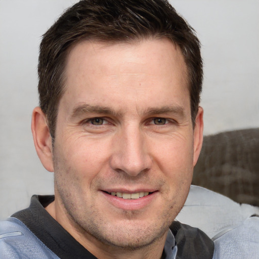 Joyful white adult male with short  brown hair and grey eyes