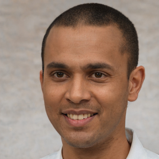 Joyful latino young-adult male with short  black hair and brown eyes
