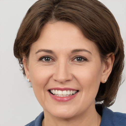 Joyful white adult female with medium  brown hair and brown eyes