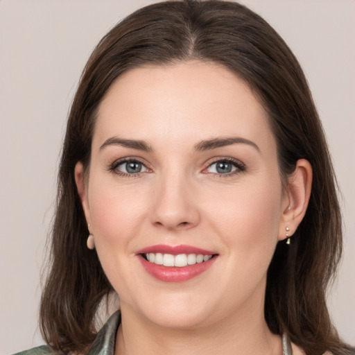 Joyful white young-adult female with medium  brown hair and grey eyes