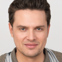 Joyful white young-adult male with short  brown hair and grey eyes