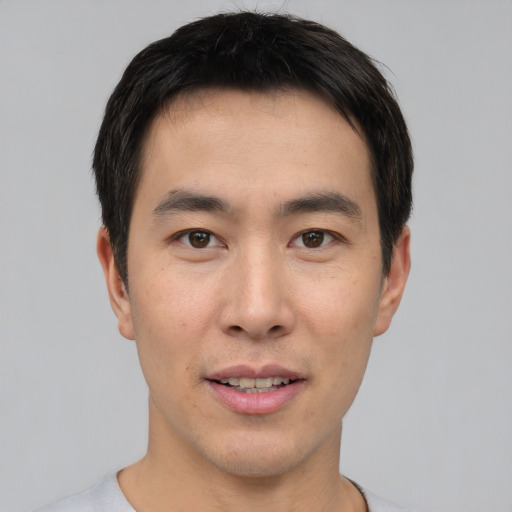 Joyful asian young-adult male with short  brown hair and brown eyes