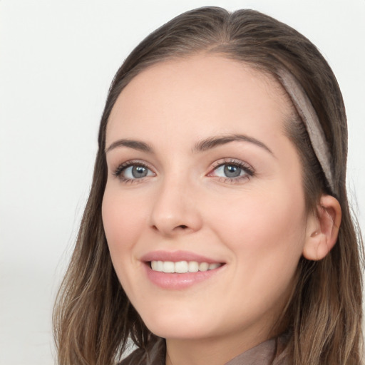 Joyful white young-adult female with long  brown hair and grey eyes