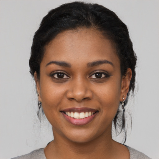 Joyful black young-adult female with medium  black hair and brown eyes