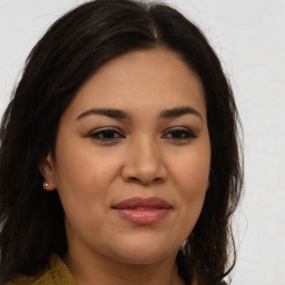 Joyful latino young-adult female with long  brown hair and brown eyes