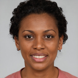 Joyful black young-adult female with short  brown hair and brown eyes