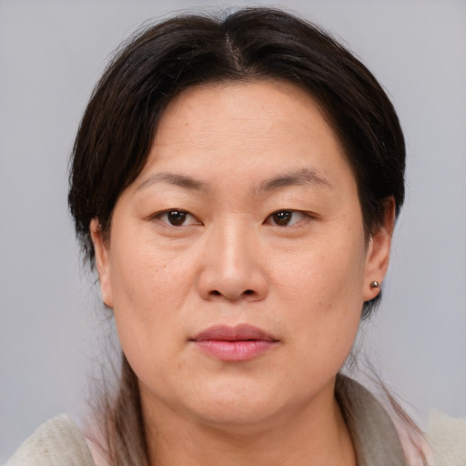 Joyful asian adult female with medium  brown hair and brown eyes