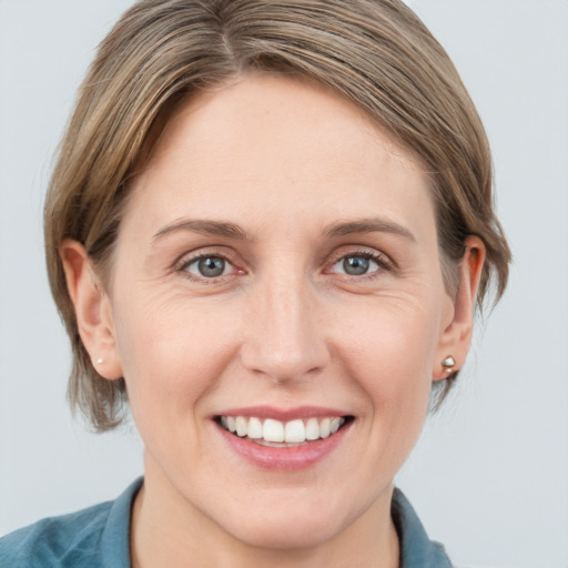 Joyful white young-adult female with medium  brown hair and grey eyes