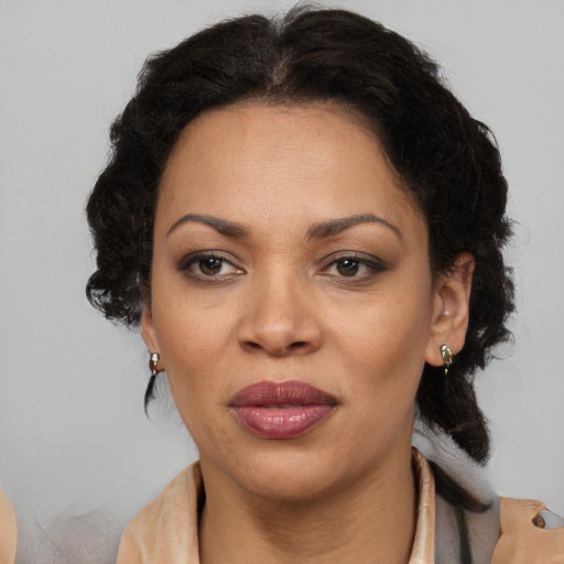 Joyful black adult female with medium  brown hair and brown eyes