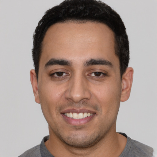 Joyful white young-adult male with short  black hair and brown eyes