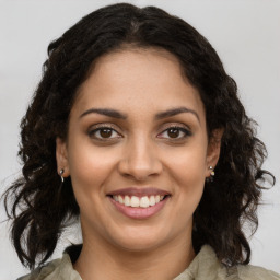 Joyful latino young-adult female with medium  brown hair and brown eyes