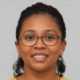 Joyful black adult female with medium  brown hair and brown eyes