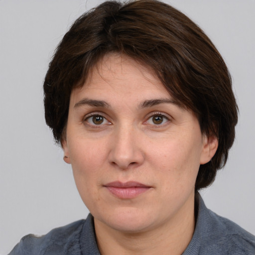 Joyful white adult female with medium  brown hair and grey eyes