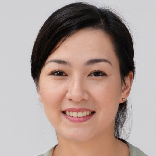 Joyful asian young-adult female with medium  black hair and brown eyes