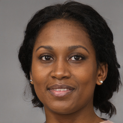 Joyful black adult female with long  black hair and brown eyes