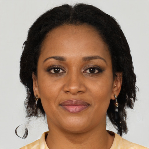 Joyful black adult female with medium  brown hair and brown eyes