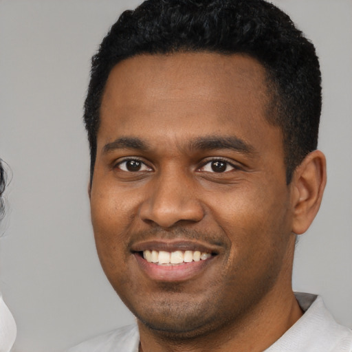 Joyful black young-adult male with short  black hair and brown eyes