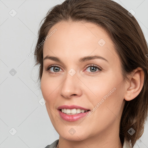 Joyful white young-adult female with medium  brown hair and grey eyes