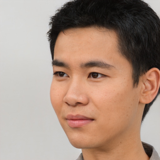 Joyful asian young-adult male with short  black hair and brown eyes