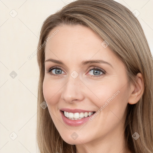 Joyful white young-adult female with long  brown hair and blue eyes