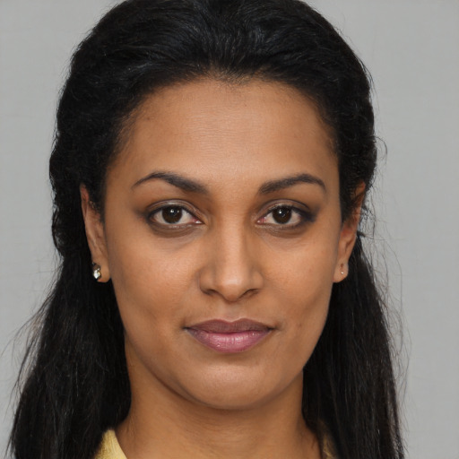 Joyful black young-adult female with long  brown hair and brown eyes