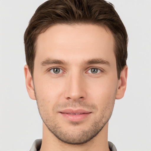 Joyful white young-adult male with short  brown hair and grey eyes