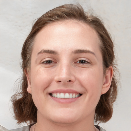 Joyful white young-adult female with medium  brown hair and blue eyes