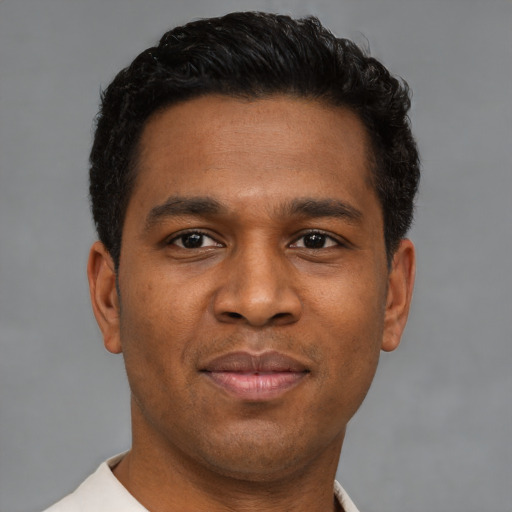 Joyful latino young-adult male with short  brown hair and brown eyes