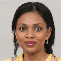 Joyful black young-adult female with medium  brown hair and brown eyes