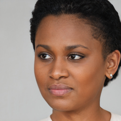 Joyful black young-adult female with short  black hair and brown eyes