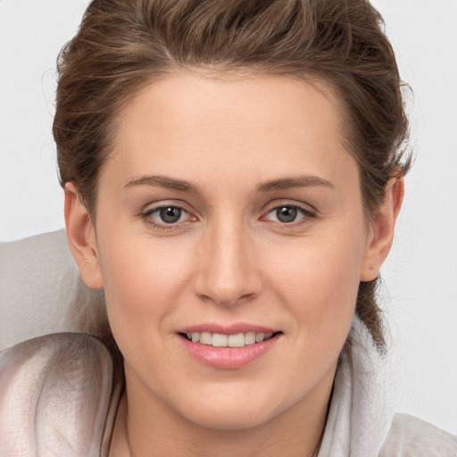 Joyful white young-adult female with medium  brown hair and grey eyes