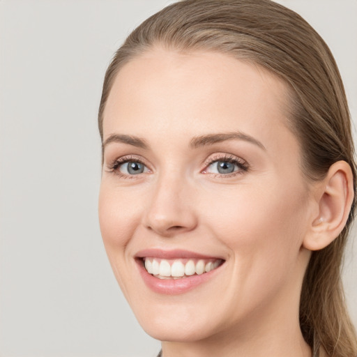 Joyful white young-adult female with long  brown hair and blue eyes