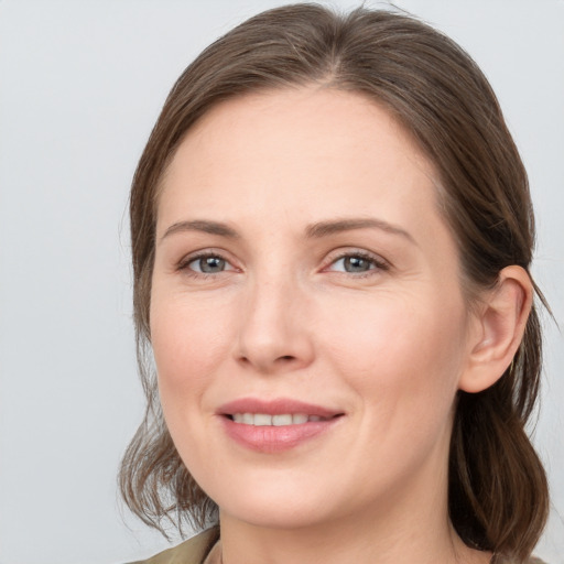 Joyful white young-adult female with medium  brown hair and grey eyes